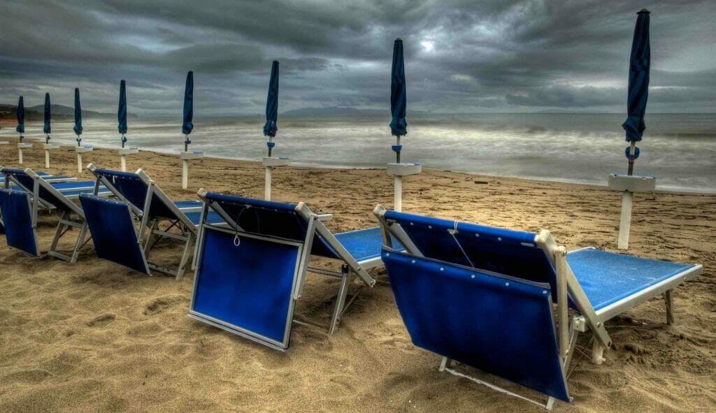 Lettini e ombrelloni a mare malptempo pioggia estate